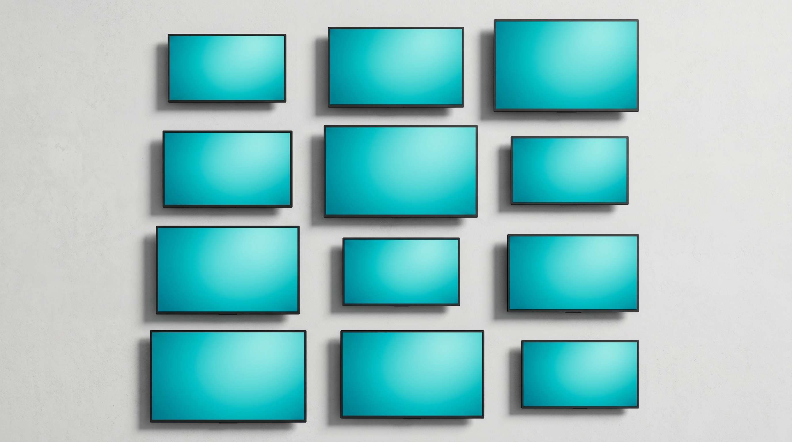Overhead editorial product photography of commercial flat-panel displays of varying sizes representing digital signage hardware pricing tiers